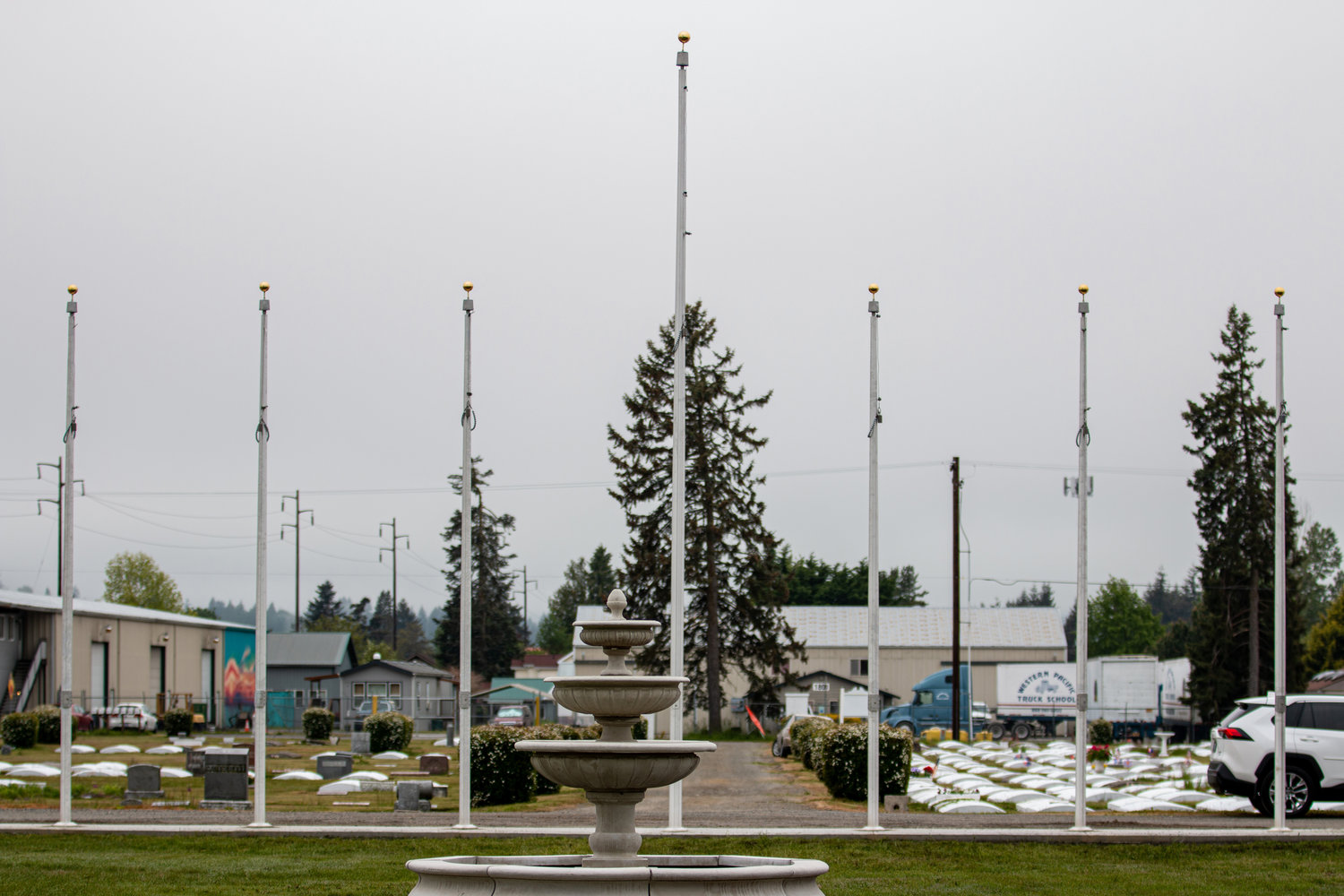 Newly erected flag poles as well as a large fountain sit at the center of the Greenwood Memorial Park.